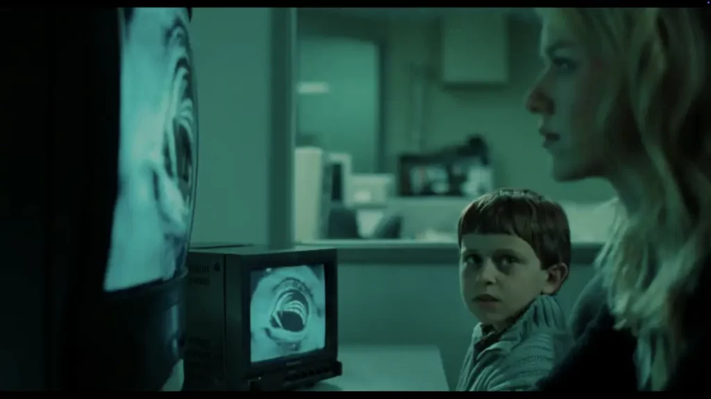 Una mujer y un niño observan con atención una pantalla que muestra una espiral hipnótica en blanco y negro.